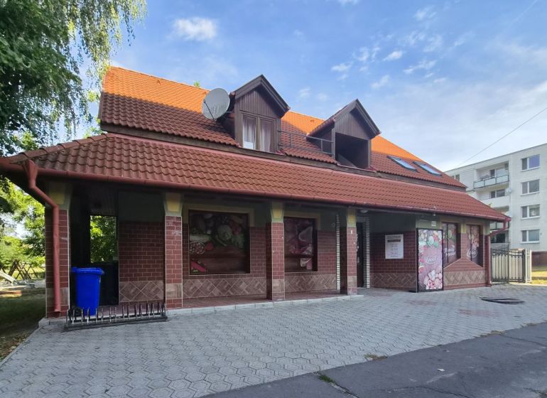 Na prenájom polyfunkčný objekt v DS - Budova v Dunajskej Strede s červenou strechou a tehlovým obkladom.