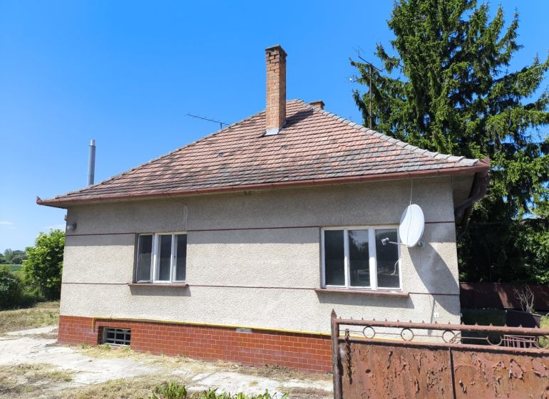 LEN U NÁS! - 4izbový rodinný dom - Michal na Ostrove - Rodinný dom v Michale na Ostrove, so satelitnou anténou a stromami v pozadí.