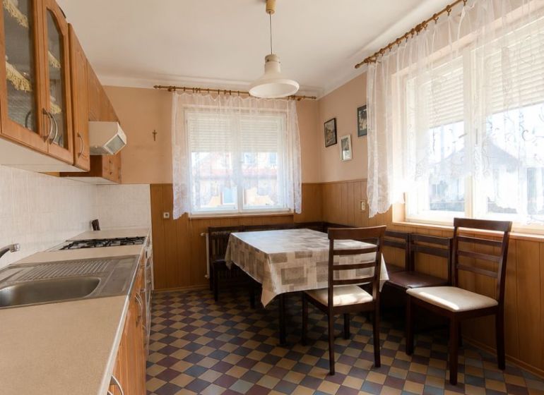 EXKLUZÍVNE LEN U NÁS! 4-izbový rodinný dom v obci Vydrany - Kuchyňa v rodinnom dome s károvanou podlahou, stolom a stoličkami pri okne.