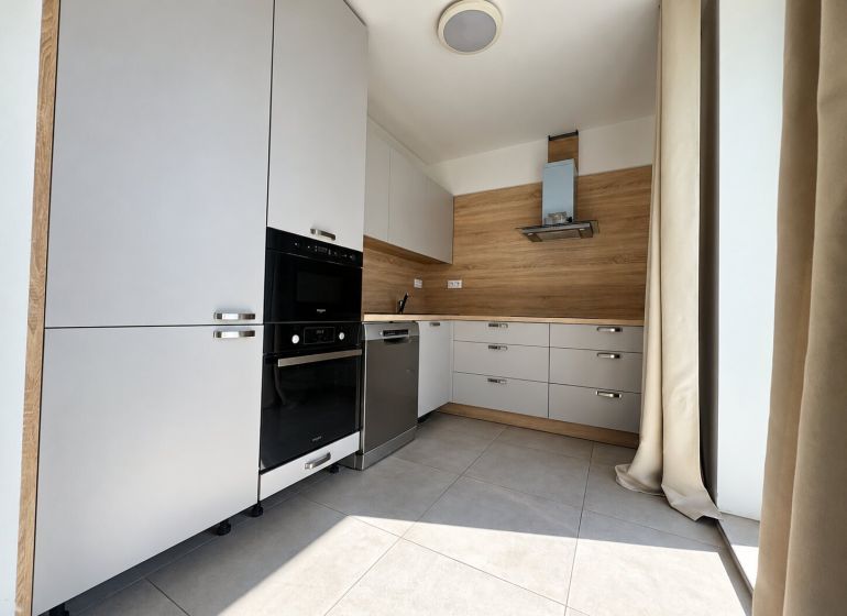 PRENÁJOM | Moderný 2-izbový byt s balkónom a parkovaním – SL - Kuchynská linka v 2-izbovom byte, svetlé prvky, podlaha s dreveným dekorom, zabudované spotrebiče.
