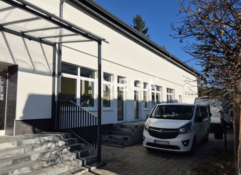 PREDAJ OBCHODNÉHO PRIESTORU v HUMENNOM (sídlisko 2A) - Budova s obchodnými priestormi na Tyršovej ulici v Humennom, zaparkované autá, strom.