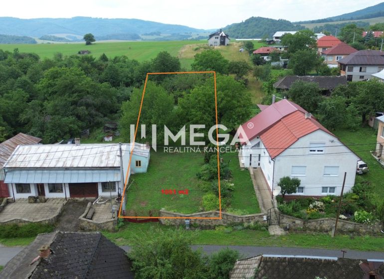 NA PREDAJ stavebný POZEMOK s LETNOU KUCHYŇOU v obci OĽŠINKOV - Pozemok v Oľšinkove vhodný na bývanie, obklopený zeleňou a neďalekými domami.