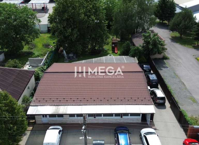NA PREDAJ PRÉMIOVÉ OBCHODNÉ PRIESTORY REŠTAURÁCIA BARÓNKA VT - Gastro priestory na Budovateľskej ulici vo Vranove nad Topľou obklopené autami a zeleňou.