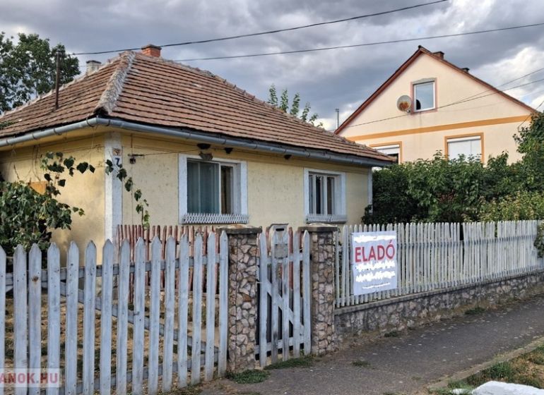 Na predaj rodinný dom v Tornyosnémeti - Rodinný dom v Tornyosnémeti s tehlovou strechou a farebným plotom.