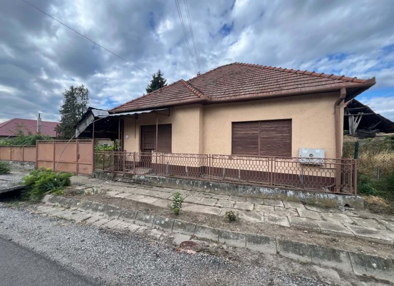 PREDAJ - Rodinný dom v obci Kamenica nad Hronom – len 5 km od Štúrova - Rodinný dom v Kamenici nad Hronom s hnedou fasádou a plechovým plotom.