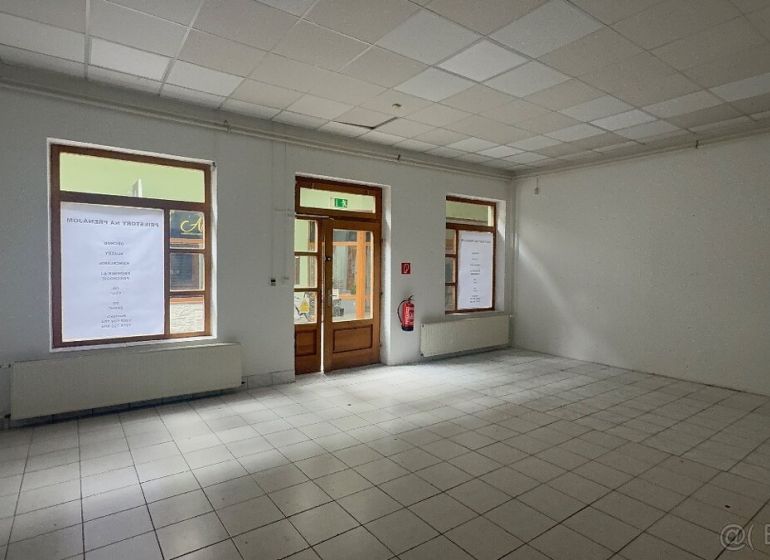 Obchodný priestor - TOP PONUKA V CENTRE - Obchodné priestory s dlažbou a veľkými oknami, čakajúce na využitie.