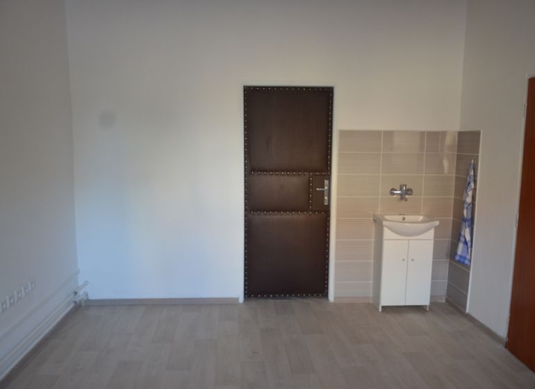 Kancelária na prenájom 15m2, Jerichova, Trnava - Interiér kancelárie s podlahou s dreveným dekorom a umývadlom.