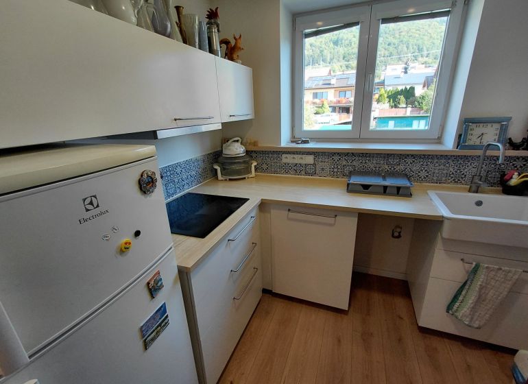 Na prenájom - Zariadený 3 izbový byt na Lipovci so záhradou - Kuchyňa v 3-izbovom byte s podlahou s dreveným dekorom a výhľadom von.