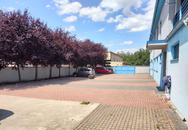 Prenájom - skladové priestory/kancelária, Vlčie hrdlo, Bratislava - Vonkajšie parkovisko pri budove, s rozložením stromov a Kancelárie v pozadí.