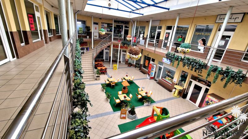 POLYFUNKČNÝ OBJEKT v Topoľčanoch NA PREDAJ - Nákupné centrum s lavičkami, obchodmi a dekoráciami, ulica Škultétyho, prehliadka budovy.