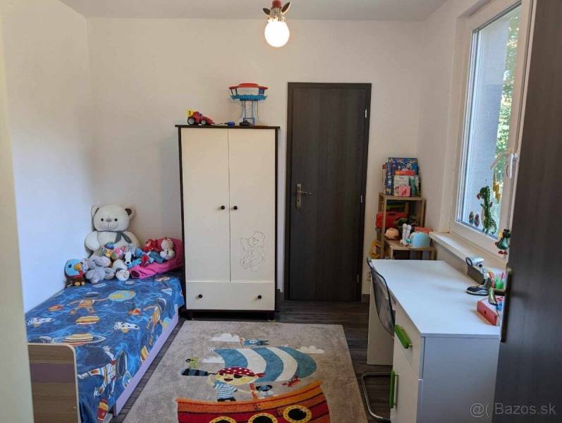 Predaj 3 izbový moderný byt v centre s balkónom - Detská izba s postieľkou, hračkami a písacím stolom, ideálne pre 3-izbový byt na ulici Okružná.