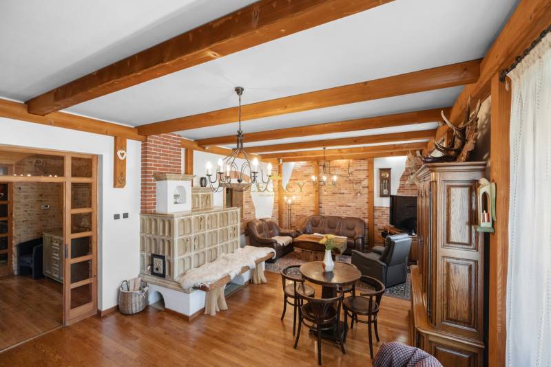 Priestranný 7-izbový dom na skok od centra – Senec - Interiér rodinného domu so štýlovým nábytkom, tehlovou stenou a krbom.