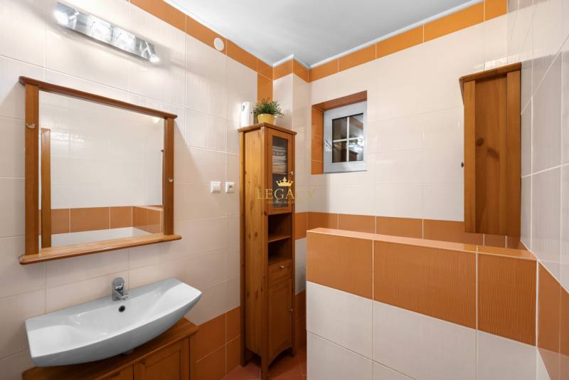 Priestranný 7-izbový dom na skok od centra – Senec - Kúpeľňa v rodinnom dome s umývadlom, keramickými dlaždicami a dreveným nábytkom.