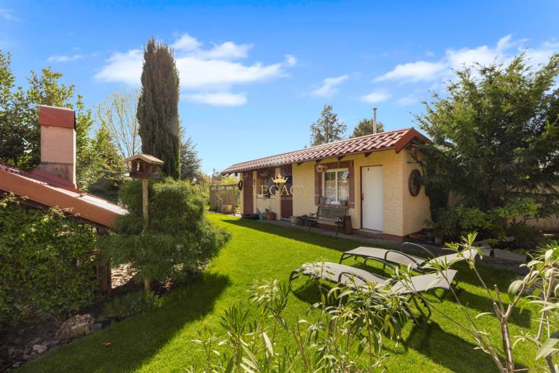 Priestranný 7-izbový dom na skok od centra – Senec - Záhrada rodinného domu v Senci s trávnikom, stromami a vonkajším sedením.