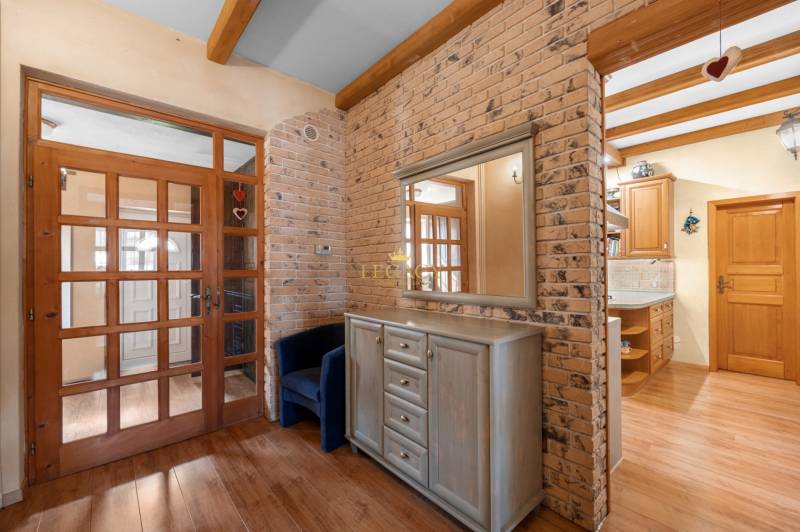 Priestranný 7-izbový dom na skok od centra – Senec - Interiér rodinného domu s tehlovou stenou, drevenými dverami a nábytkom.