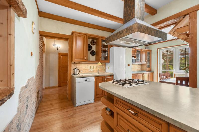 Priestranný 7-izbový dom na skok od centra – Senec - Drevená kuchyňa v rodinnom dome s ostrovčekom, spotrebičmi a jedálenským kútom.