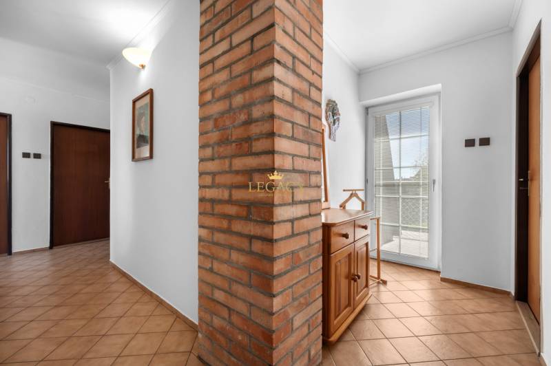 Priestranný 7-izbový dom na skok od centra – Senec - Vstupná hala Rodinného domu s tehlovou stenou a dreveným nábytkom.