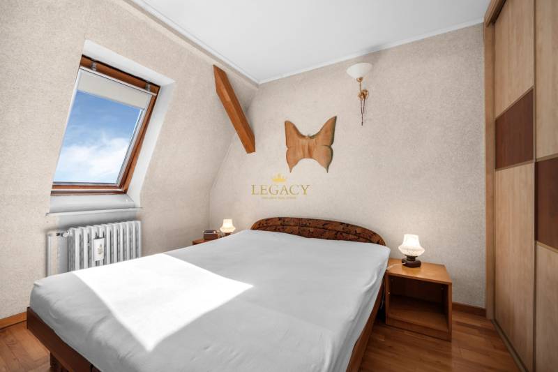 Priestranný 7-izbový dom na skok od centra – Senec - Spálňa v rodinnom dome s dreveným nábytkom, strešným oknom a dekoráciou na stene.