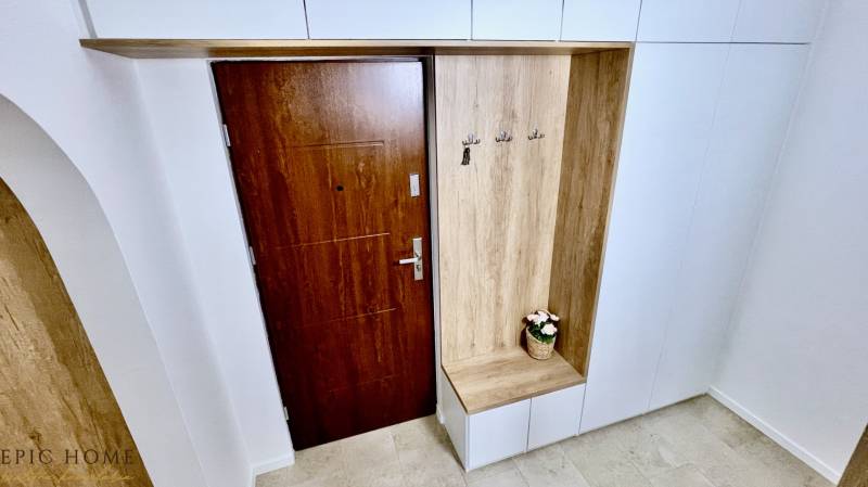 TOP ZREKONŠTRUOVANÝ PRIESTRANNÝ 2-IZBOVÝ BYT S PREDZÁHRADKOU,  BA IV - Vstupná hala v 2-izbovom byte s drevenými dverami a vešiakom.