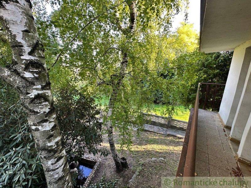 Rodinný domček na kopci vo vinárskej obci Veľký Kýr - Balkón rodinného domu obklopený zeleňou, stromami a záhradou poskytuje pokojný výhľad.