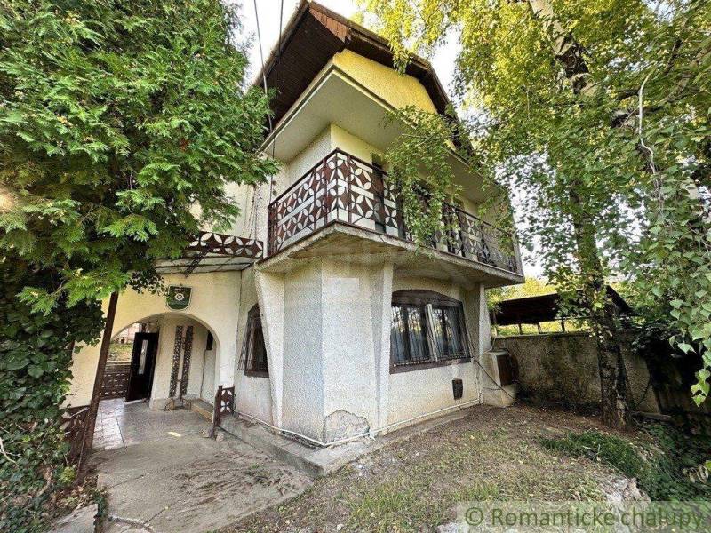 Rodinný domček na kopci vo vinárskej obci Veľký Kýr - Rodinný dom so staršou architektúrou, obklopený zeleňou, s balkónom a drevenými detailmi.