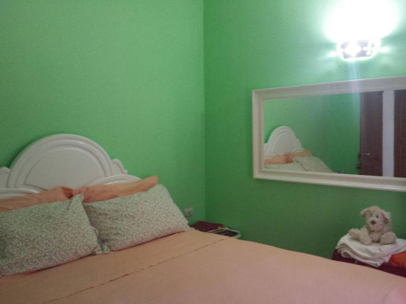 Štýlový 2 izb. apartmán pri bazéne Dominikanska Republika - Spálňa v zelených farbách s bielou posteľou v 2-izbovom byte na ulici Avenida Wayne Fuller.