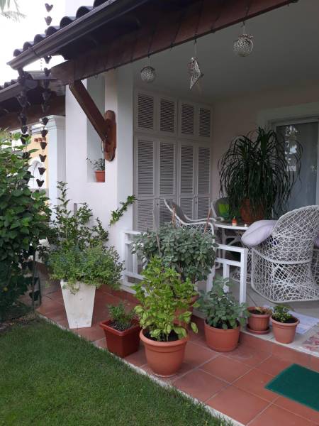 Štýlový 2 izb. apartmán pri bazéne Dominikanska Republika - Malá terasa s kreslami, kvetmi a dekoráciami, vedľa 2-izbový byt na ulici Avenida Wayne Fuller.