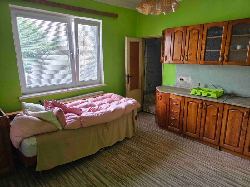 Dulovce - RODINNÝ DOM so 700 m2 POZEMKOM - Zelená miestnosť s drevenou kuchynskou linkou a posteľou v Rodinnom dome.