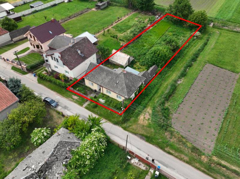 Dulovce - RODINNÝ DOM so 700 m2 POZEMKOM - Letecký pohľad na rodinný dom v Dulovciach s veľkou záhradou a okolím.