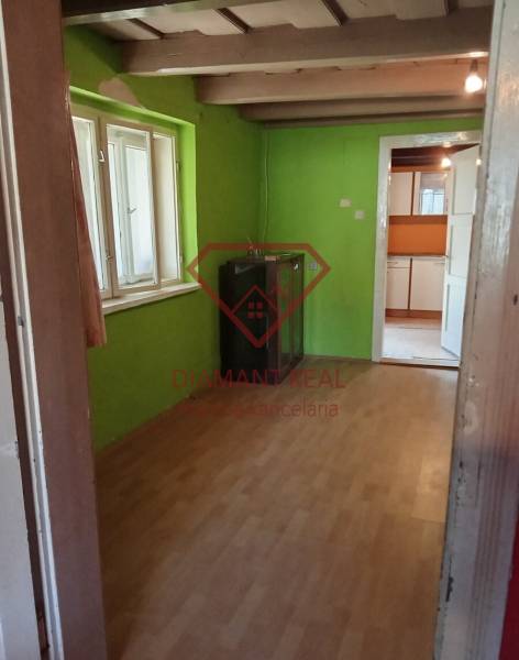 Na predaj stavebný pozemok 3655 m2 Zemianske Sady okr. Galanta  - Rodinný dom s dreveným stropom, zelené steny a laminátová podlaha.