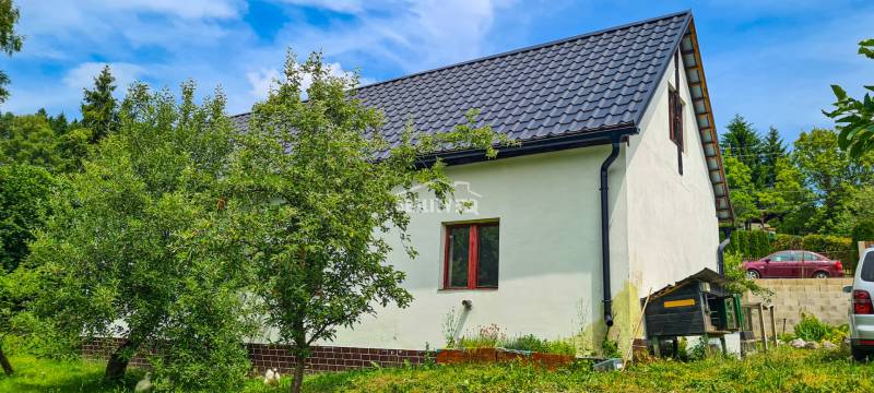 Predaj dva rodinné domy v Lietave pri Žiline - Rodinný dom v Lietave s plechovou strechou, okolitá zeleň a parkujúce autá.