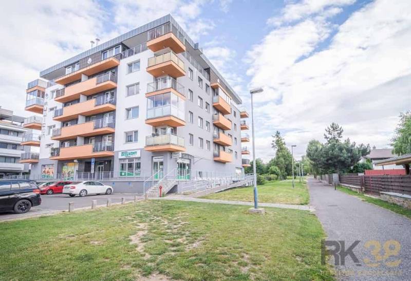 Rezervované: Na predaj pekný 2-izbový byt Poprad-Veľká - Obývacia izba v 3-izbovom byte s modrou sedačkou a drevenými prvkami.