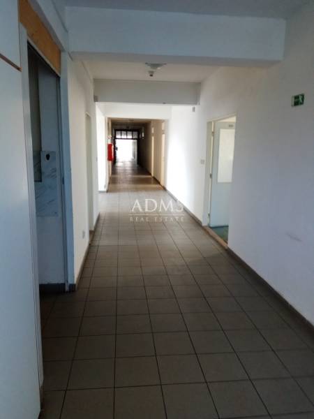 Administratívno-skladová budova Bratislava - Trnávka - Úzky, dlhý interiérový koridor vo výrobných priestoroch s dverami pozdĺž chodby.