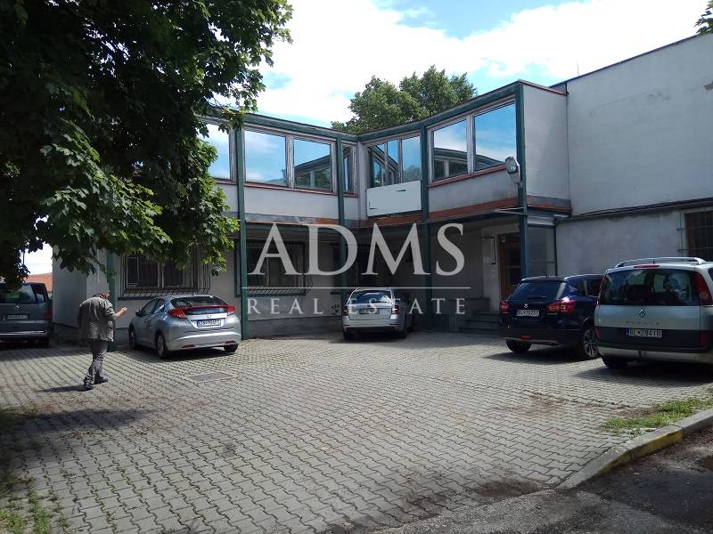 Administratívno-skladová budova Bratislava - Trnávka - Dvor s parkujúcimi autami pri výrobných priestoroch na Beckovskej ulici v Bratislave - Ružinove.