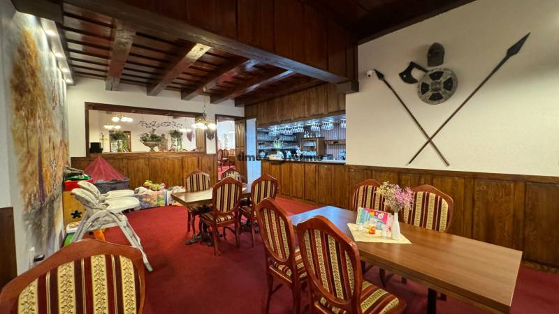 NA PREDAJ hotel s reštauráciou - Reštaurácia s dreveným stropom, červeným kobercom a ozdobnými predmetmi na stene pre penzióny.