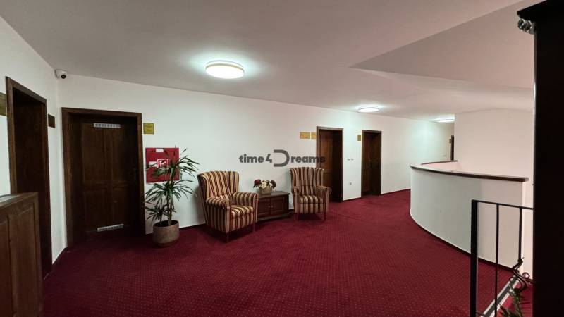 NA PREDAJ hotel s reštauráciou - Chodba s červeným kobercom, kreslami a izbami vo vnútri hotela alebo penziónu.