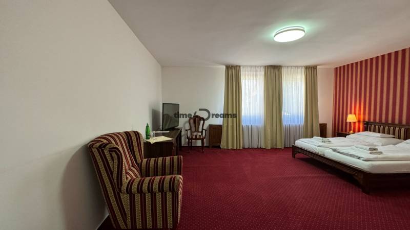 NA PREDAJ hotel s reštauráciou - Izba s červeným kobercom, dvojposteľou, kreslom a televíziou. Hotely a penzióny.