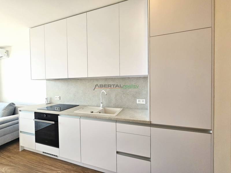 PRENÁJOM- 1i byt, klima, parking, loggia,Olivia Residence, Rožňavska - Kuchynská linka v 1-izbovom byte s bielymi skrinkami a vstavanými spotrebičmi.