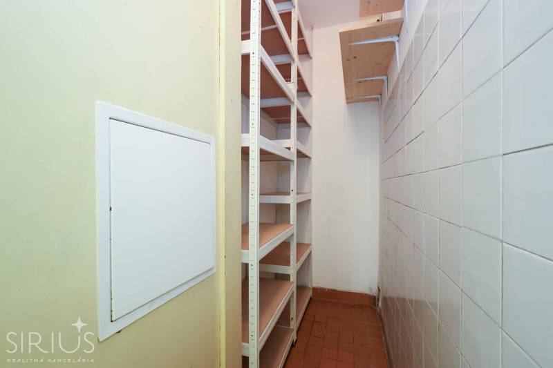 BÝVANIE NA HRADOM KOPCI - 3i byt, 90 m2 s balkónom, SVETLÁ ulica - Úzky priestor s regálmi a dlaždicami v 3-izbovom byte.