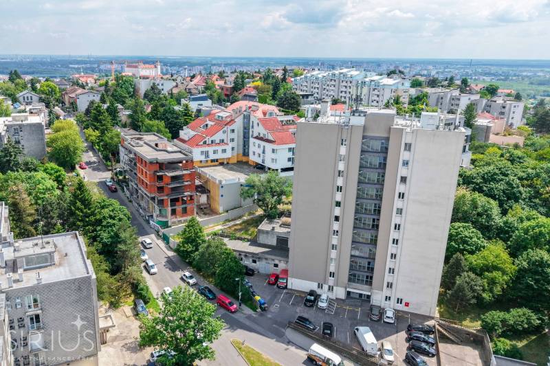 BÝVANIE NA HRADOM KOPCI - 3i byt, 90 m2 s balkónom, SVETLÁ ulica - Výhľad na Bratislavu - Staré Mesto z ulice Svetlá s viacerými obytnými budovami a zeleňou.