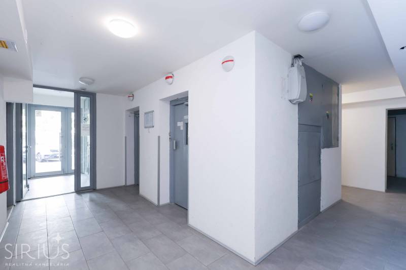 BÝVANIE NA HRADOM KOPCI - 3i byt, 90 m2 s balkónom, SVETLÁ ulica - Vstupná hala s výťahom, dverami a dlažbou v 3-izbovom byte.