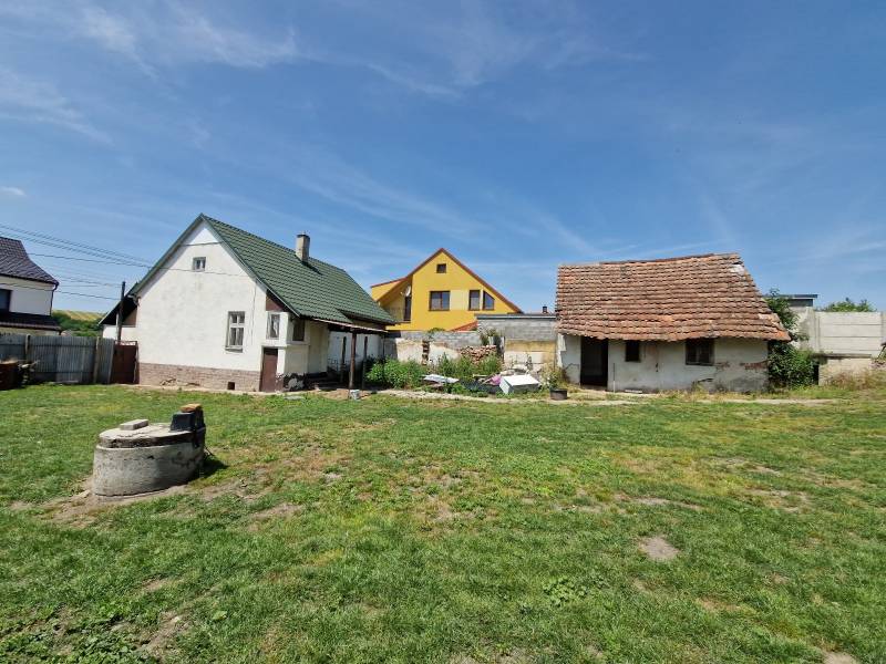 NA PREDAJ RODINNÝ DOM V OBCI ŠTEFANOV, OKRES SENICA - Rodinný dom v Štefanove s dvoma stavbami na dvore a kopcom trávy.