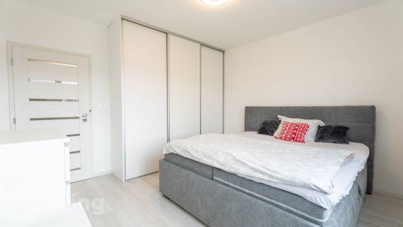ZARIADENÝ - 3i v novostavbe 76 m2 + balkon - Trenčín - Spálňa v 3-izbovom byte s posteľou, skriňou a svetlými dverami.