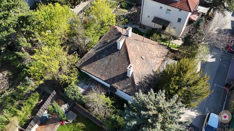 STARŠÍ RODINNÝ DOM S 669 m2 POZEMKOM v lukratívnej lokalite BA I. - Letecký pohľad na rodinný dom obklopený zeleňou na ulici Banícka.