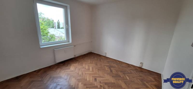 PREDAJ: 3 izbový byt s balkónom, 72 m2 - KOMÁRNO - Prázdna izba s parketovou podlahou a oknom v 3-izbovom byte.