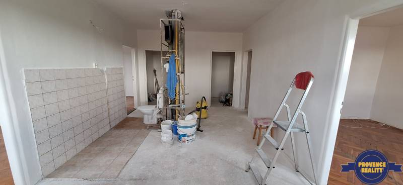 PREDAJ: 3 izbový byt s balkónom, 72 m2 - KOMÁRNO - Interiér 3-izbového bytu pred rekonštrukciou s rebríkom, vedrami a náčiním.