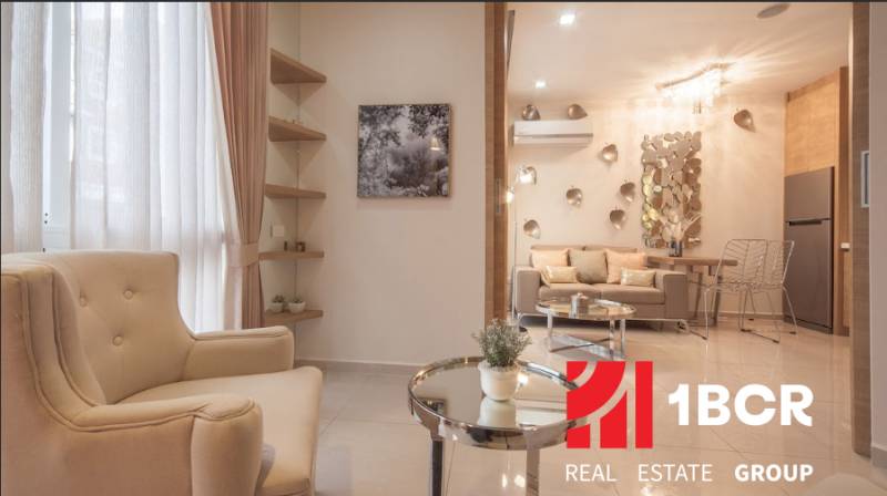 1 IZBOVÝ APARTMÁN A (1 SPÁLŇA + 1 OBÝV. IZBA) CITY GARDEN OLYMPUS  - Štýlový obývací priestor s pohodlným kreslom a dekoráciami v 2-izbovom byte.