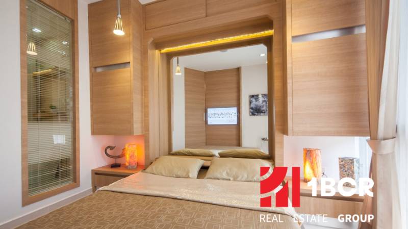 1 IZBOVÝ APARTMÁN A (1 SPÁLŇA + 1 OBÝV. IZBA) CITY GARDEN OLYMPUS  - Štýlová spálňa v 2-izbovom byte s drevenými prvkami a veľkým zrkadlom.