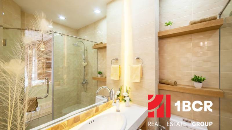 1 IZBOVÝ APARTMÁN A (1 SPÁLŇA + 1 OBÝV. IZBA) CITY GARDEN OLYMPUS  - Elegantná kúpeľňa v 2-izbovom byte so sprchovacím kútom a dekoratívnym osvetlením.