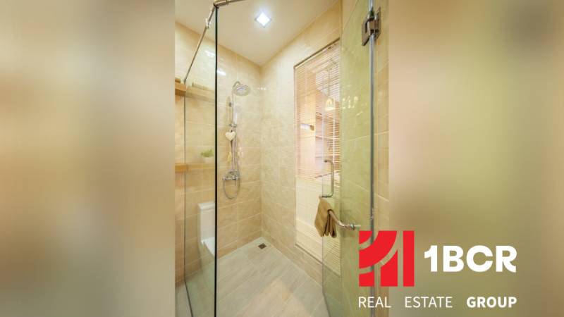 1 IZBOVÝ APARTMÁN A (1 SPÁLŇA + 1 OBÝV. IZBA) CITY GARDEN OLYMPUS  - Kúpeľňa v 2-izbovom byte s preskleným sprchovacím kútom a svetlým obkladom.